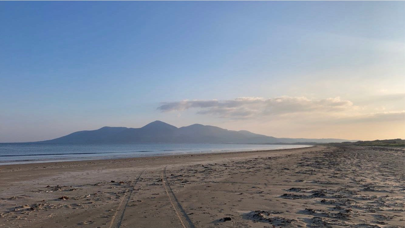 An image of the Mourne Mountains in County Down Northern Ireland taken at sunset from Ballykinlar beach.