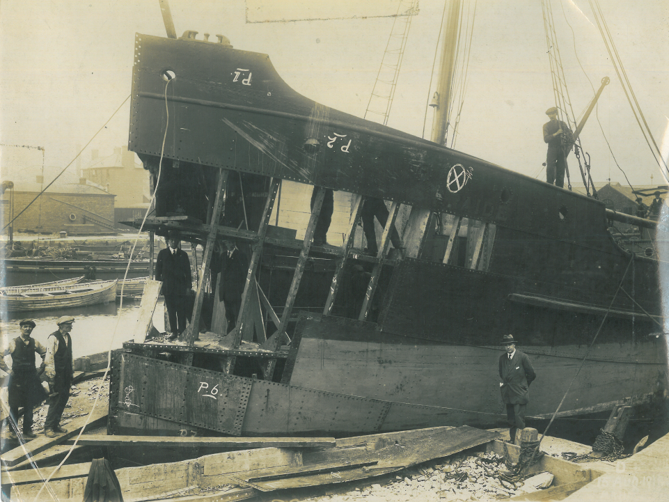 Workers stand around the SS Straide where the front panels around the previously damaged bow have been removed