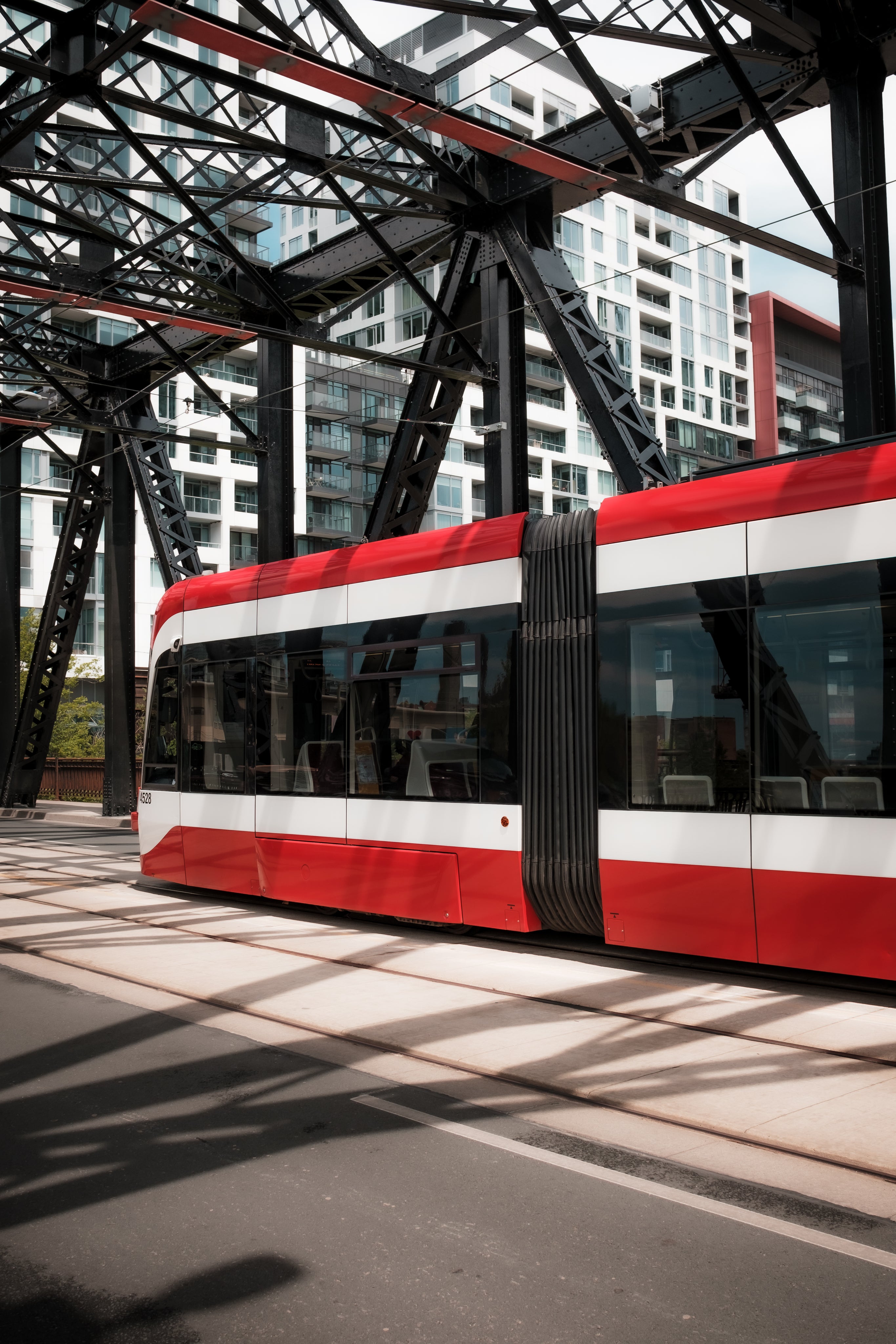 A modern public transport vehicle drives under a bridge