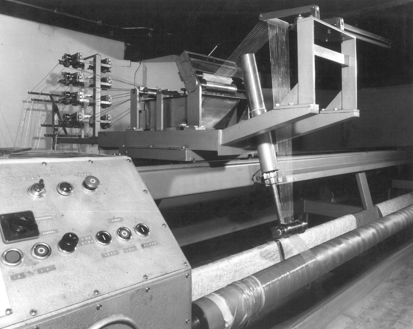 A black and white photo of filament winding when the technology was in its infancy and being developed with more automated equipment